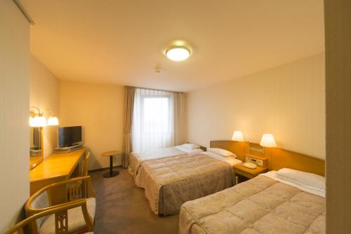 Postel nebo postele na pokoji v ubytování Sky Hotel Uozu Annex