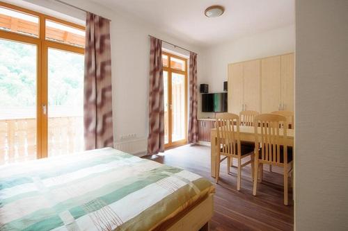 sypialnia z łóżkiem, stołem i krzesłami w obiekcie Madronič family estate - Kolpa river w mieście Stari Trg ob Kolpi