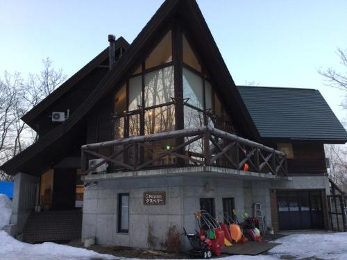 a house with a large window on the side of it at Pension Gooseberry in Furano