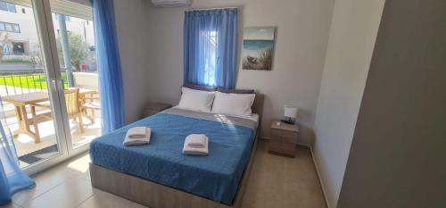 a bedroom with a bed with two towels on it at F&R VILLA in Neoi Epivates