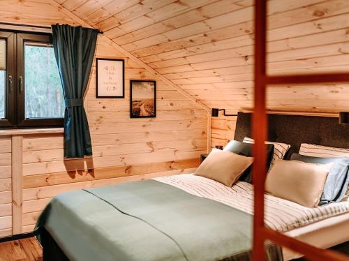 um quarto com uma cama num chalé de madeira em Chata Leśna Polana em Kurzetnik