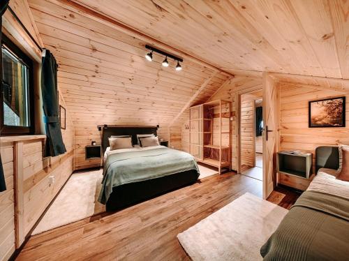 a bedroom with a bed and a tv in a room at Chata Leśna Polana in Kurzętnik