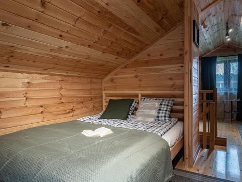 a bedroom with a bed in a wooden cabin at Chata Leśna Polana in Kurzętnik