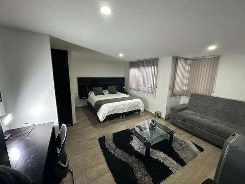 een woonkamer met een bed en een bank bij HOTEL JARDIN 38 in Pasto