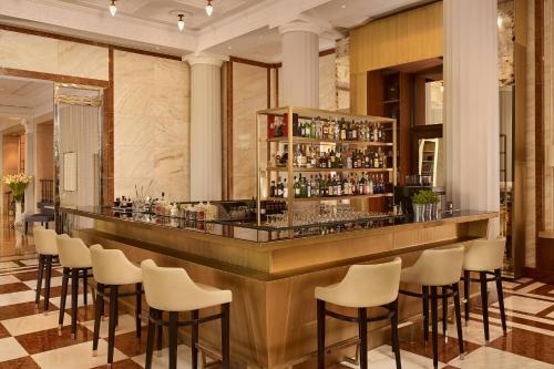 a bar with white stools in a hotel room at Al Habtoor Palace Budapest, Preferred Hotels & Resorts in Budapest