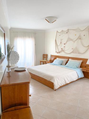 a bedroom with a large bed and a table at Buzio e Mar in Portimão