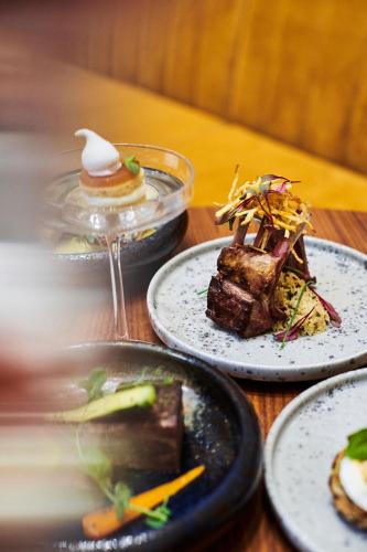 three plates of food on a wooden table at Al Habtoor Palace Budapest, Preferred Hotels & Resorts in Budapest