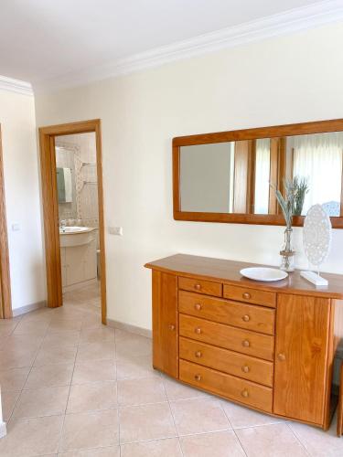 a bathroom with a wooden dresser and a mirror at Buzio e Mar in Portimão
