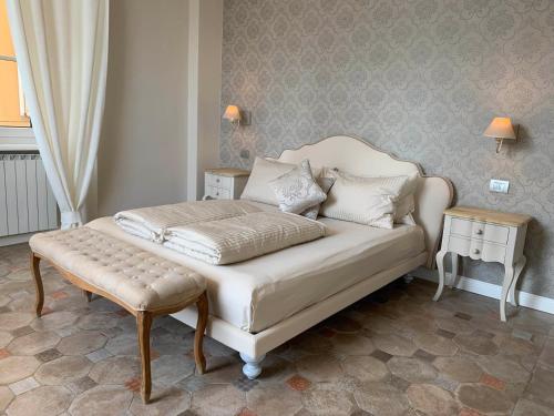 a bedroom with a white bed and a stool at Spiaggia Amore - Appartamenti Vacanza Vista Lago in Cannobio
