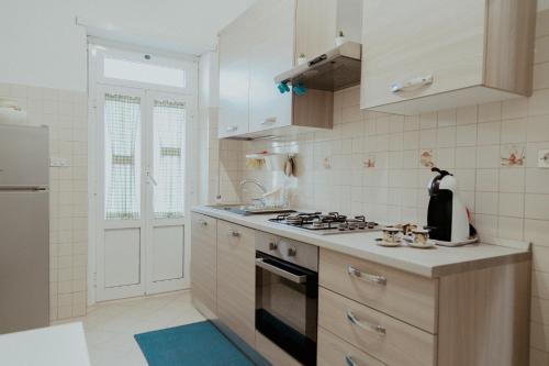 a kitchen with white cabinets and a stove top oven at La casa di Grazia in Rome