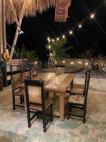 a wooden table with two chairs and a wooden table with lights at finca playa seca in Santa Fe de Antioquia