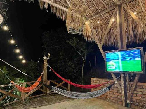 a hammock in a resort with a tv and a screen at finca playa seca in Santa Fe de Antioquia