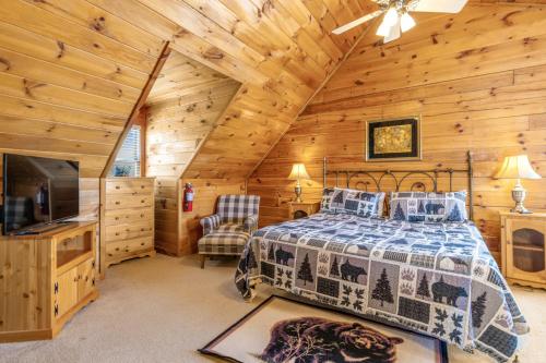 a bedroom with a bed and a television in a cabin at Papaw's Bear Den in Pigeon Forge
