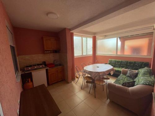 een woonkamer met een tafel en een bank en een keuken bij Apartments Zeneva in Donji Štoj