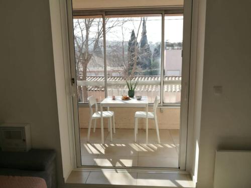 widok na stół i krzesła na balkonie w obiekcie Joli Studio à Sanary-sur-Mer w mieście Sanary-sur-Mer