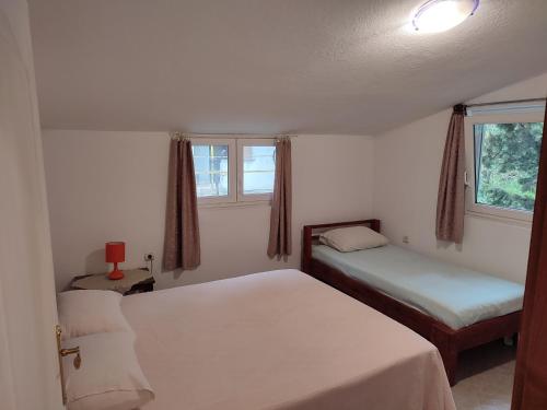 1 Schlafzimmer mit 2 Betten und 2 Fenstern in der Unterkunft Bay Mola Aparts in Kotor