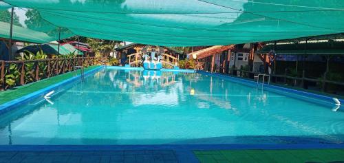 a large blue swimming pool with a blue canopy at Villa Lenda Resort - San Manuel, Pangasinan 