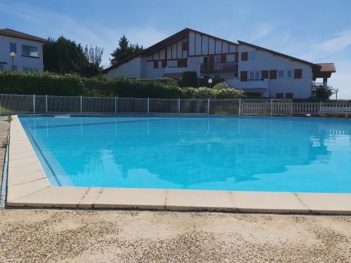 une grande piscine bleue devant une maison dans l'établissement Appartement à Hendaye avec piscine et à côté de la plage, à Hendaye