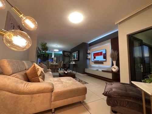 a living room with a couch and a flat screen tv at D&DLuxury Rivonia Apartments with inverter in Johannesburg