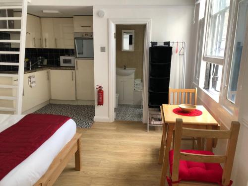 ロンドンにあるWestbourne Terraceのベッド、テーブル、キッチンが備わる客室です。
