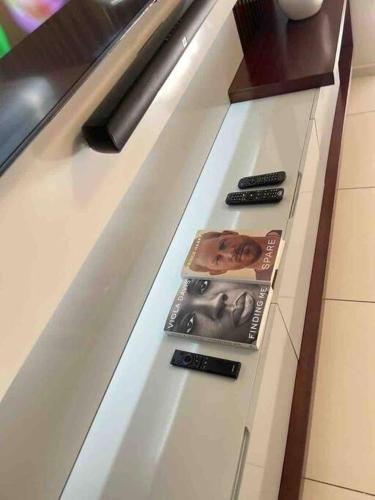 a kitchen counter with three remote controls on it at D&DLuxury Rivonia Apartments with inverter in Johannesburg