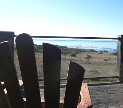 a wooden fence with a view of the ocean at Holmes in Sea Ranch