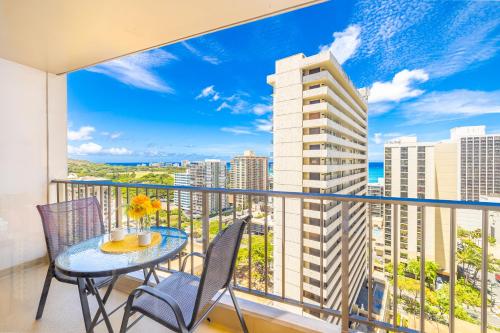 a balcony with a table and chairs and a view of the city at Great Ocean View at Waikiki Sunset with Parking in Honolulu