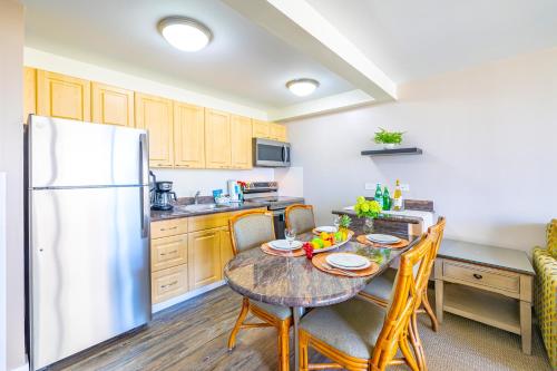 a kitchen with a table and a refrigerator at Great Ocean View at Waikiki Sunset with Parking in Honolulu