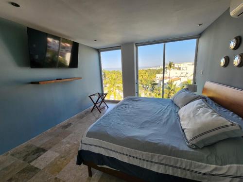 a bedroom with a large bed with a large window at Lovely 4 bedroom penthouse Terra PH23 QueridaEstancia in Nuevo Vallarta 