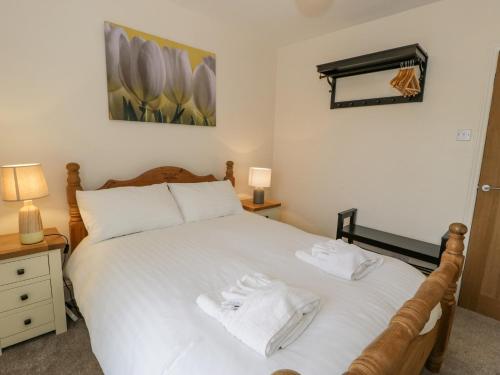 ポルスマドグにあるGwelforのベッドルーム1室(白いベッド1台、タオル付)