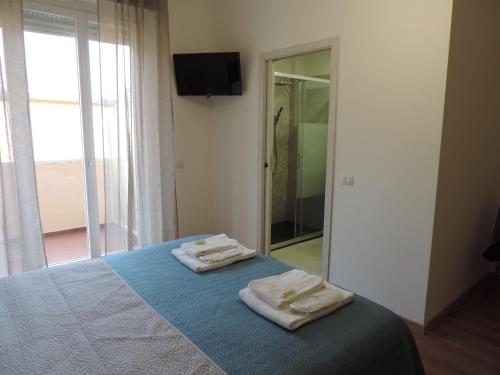 een slaapkamer met een bed met twee handdoeken erop bij Sciesa Guest House in Verona