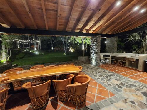un patio con mesa de madera y sillas en Cabaña del Bosque Tapalpa Country Club L7M15 QueridaEstancia, en Tapalpa