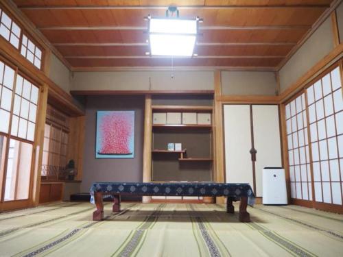 a room with a bench in a room with windows at 体験民宿NORA in Mukaigawa