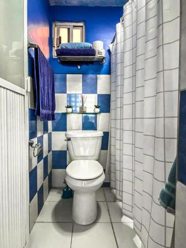 a bathroom with a toilet and blue and white tiles at Departamento a 25 min del AIFA in Ecatepec