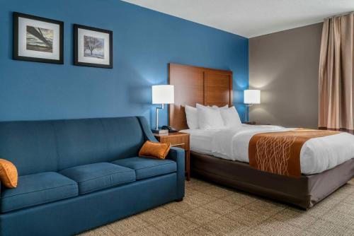 um quarto de hotel com uma cama e um sofá em Comfort Inn East em Oregon