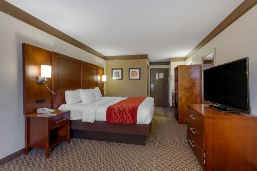 a hotel room with a bed and a flat screen tv at Comfort Inn Mount Vernon Downtown in Mount Vernon