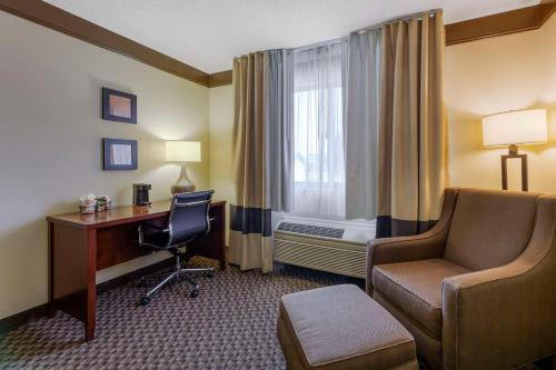 a hotel room with a desk and a chair and a bed at Comfort Inn Mount Vernon Downtown in Mount Vernon