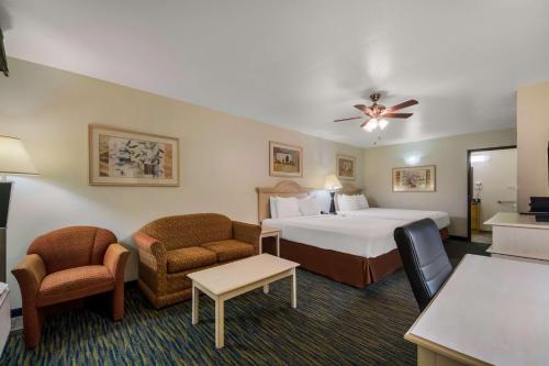 a hotel room with a bed and two chairs at SureStay Hotel by Best Western Falfurrias in Falfurrias
