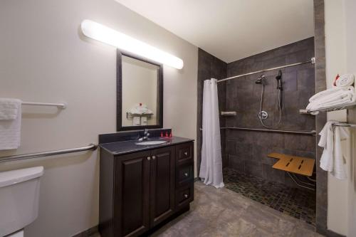 a bathroom with a sink and a shower at SureStay Hotel by Best Western Falfurrias in Falfurrias