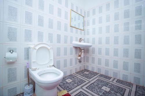 a bathroom with a toilet and a sink at Hilton View Hotel in Accra