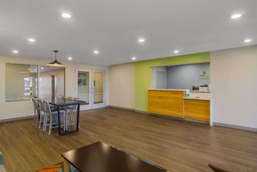 WoodSpring Suites Jacksonville Orange Park في أورانج بارك: غرفة معيشة مع طاولة ومطبخ