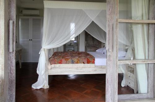 a bedroom with a bed with a canopy at Papaya Guesthouse in Canggu
