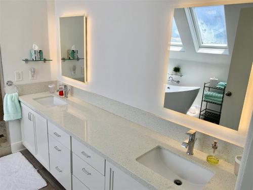 a bathroom with two sinks and two mirrors at 125-fun In The Sun Penthouse in San Diego