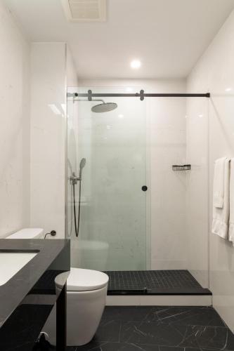 a bathroom with a toilet and a glass shower at Broadway Plaza Hotel in New York