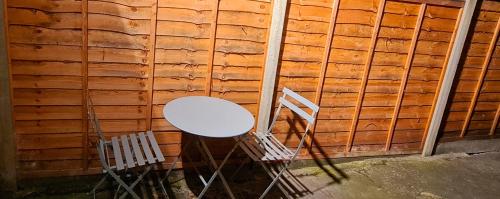 a white table and a chair next to a wall at Cosy flat - with excellent transport links in South Norwood