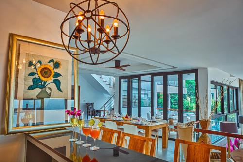 a dining room with a table and a chandelier at Fully Serviced Grand Villa Luxury Time Phuket in Bang Tao Beach
