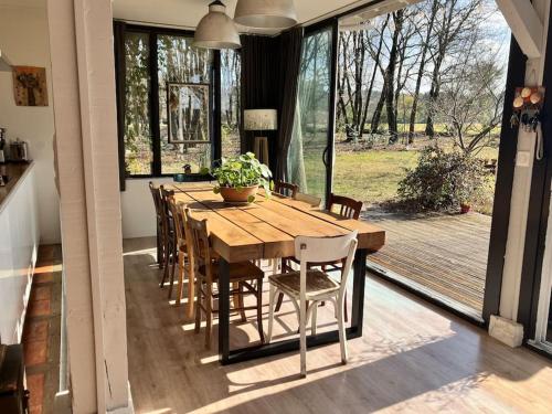 une salle à manger avec une table et des chaises en bois dans l'établissement Havre de paix à 15 km des plages, à Soustons