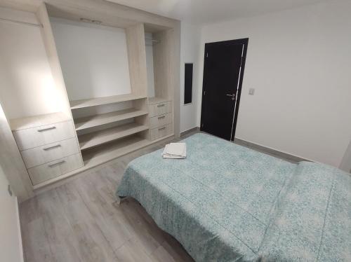1 dormitorio con cama, tocador y espejo en ALMAR FONTANA en Comodoro Rivadavia