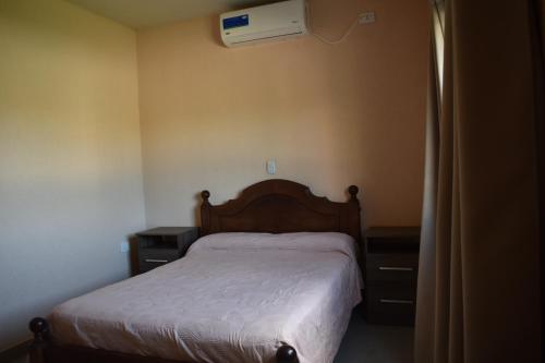 1 dormitorio con 1 cama y aire acondicionado en la pared en Finca Las Tres Hermanas en La Banda en La Banda