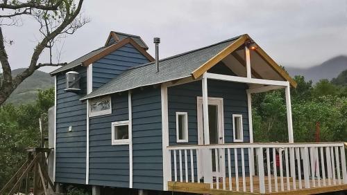 ein blaues Haus mit einer Veranda und einem Balkon in der Unterkunft Tiny House Garden - Aparados da Serra - SC in Praia Grande